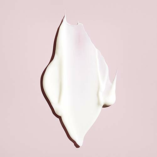 Swatch of white cosmetic cream on pink background