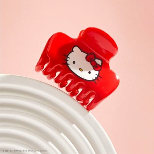 Red Hello Kitty hair clip on a white surface