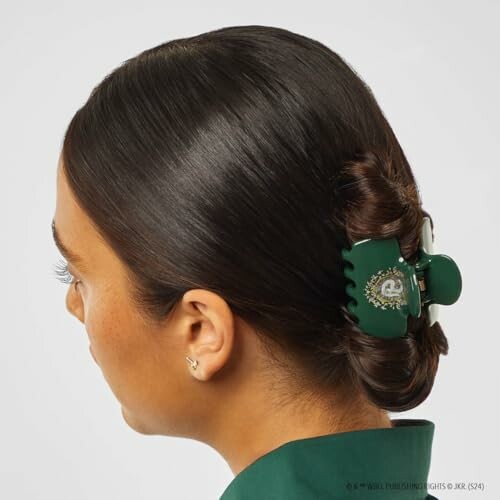 Woman with dark hair twisted into a bun using a green hair clip.