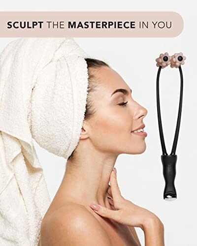 Woman with towel using a face massager